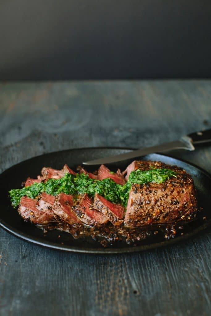 Sirloin Steak in a Cast Iron Skillet drizzled with Chimichurri Sauce Sirloin Steak in a Cast Iron Skillet drizzled with Chimichurri Sauce