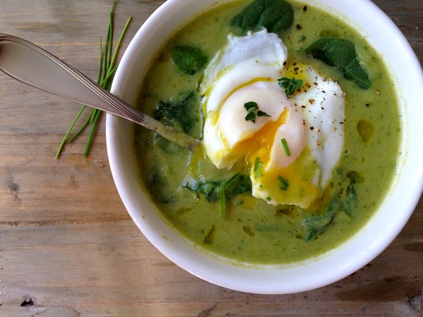 White bowl of green Broccoli Spinach Soup with a creamy poached egg on top White bowl of green Broccoli Spinach Soup with a creamy poached egg on top