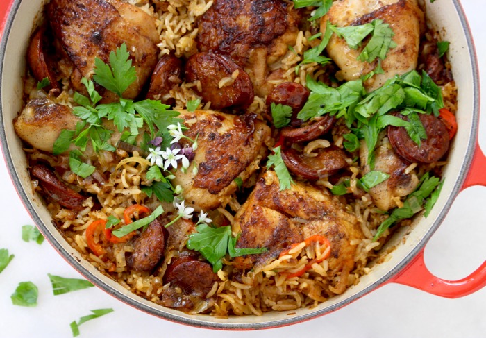 Red pot with baked chicken and brown rice, andouille sausage, leeks and with parsley Red pot with baked chicken and brown rice, andouille sausage, leeks and with parsley