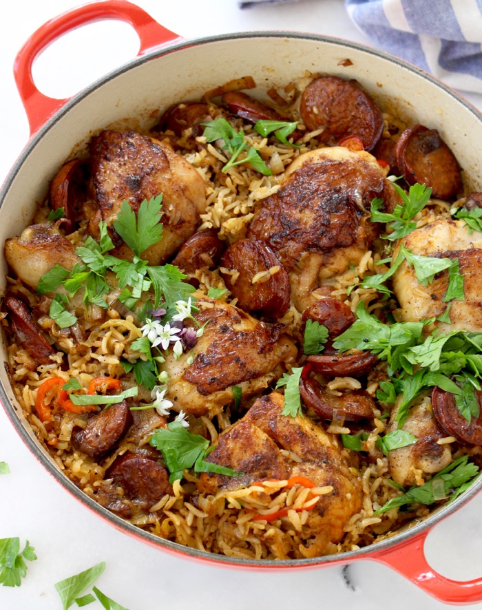 Red pot with baked chicken and brown rice, andouille sausage, leeks and with parsley Red pot with baked chicken and brown rice, andouille sausage, leeks and with parsley