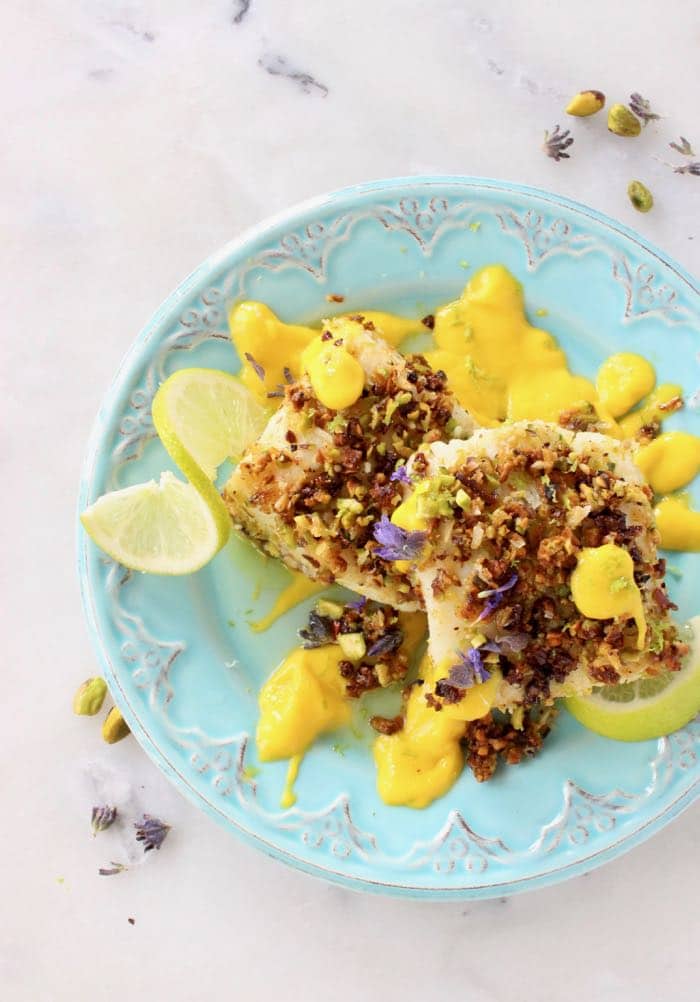 Serving platter with baked cod fish fillets in coconut pistachio crust with mango sauce Serving platter with baked cod fish fillets in coconut pistachio crust with mango sauce